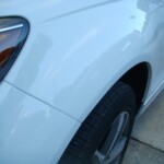 Before and after photographs of a damaged white, AUDI Quattro SUV that was repaired by Elite Paint & Body Shop in West Palm Beach, Florida.